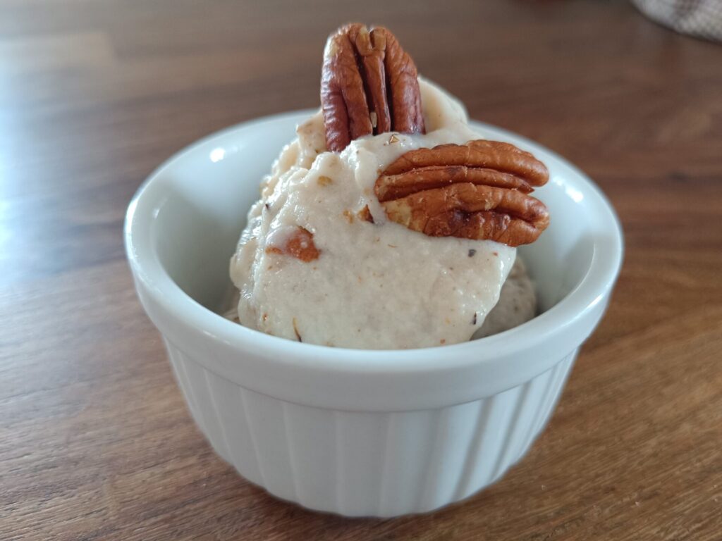 Nice cream z nashi hruško in praženimi pekan orehi v beli skodelici
