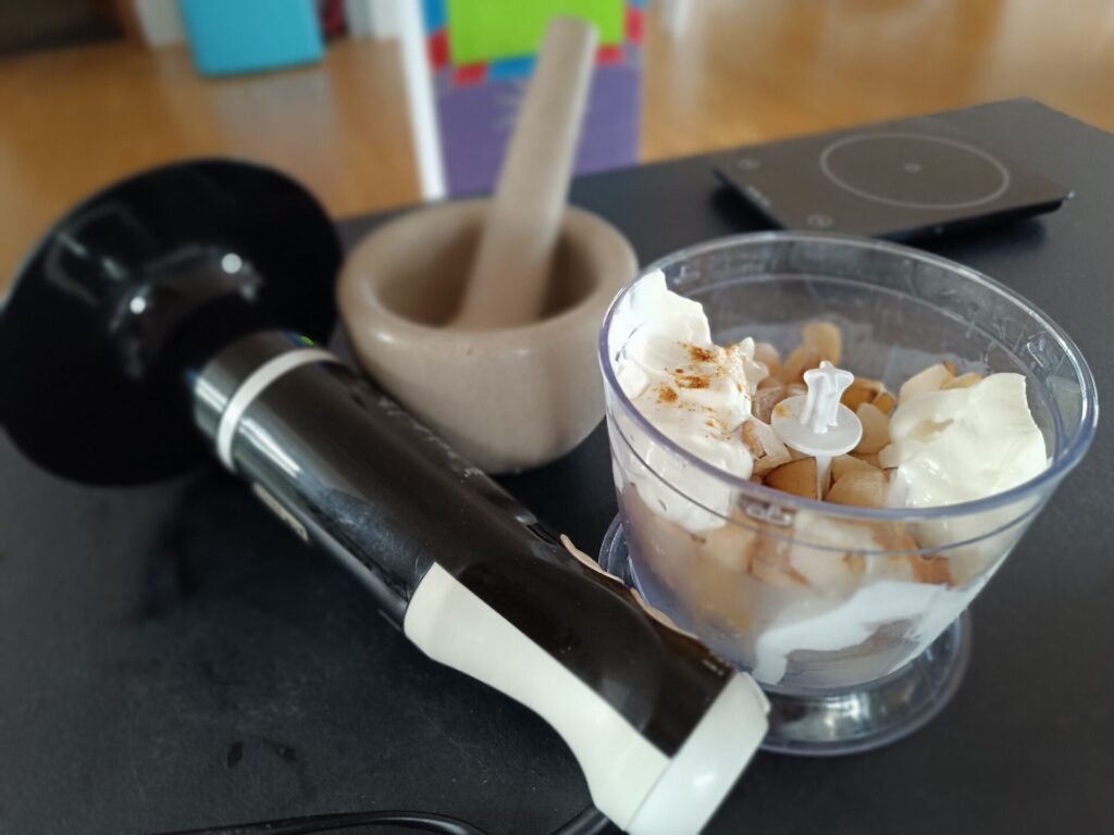 Zamrznjena banana, nashi hruška in jogurt v sekljalniku pred pripravo nice creama